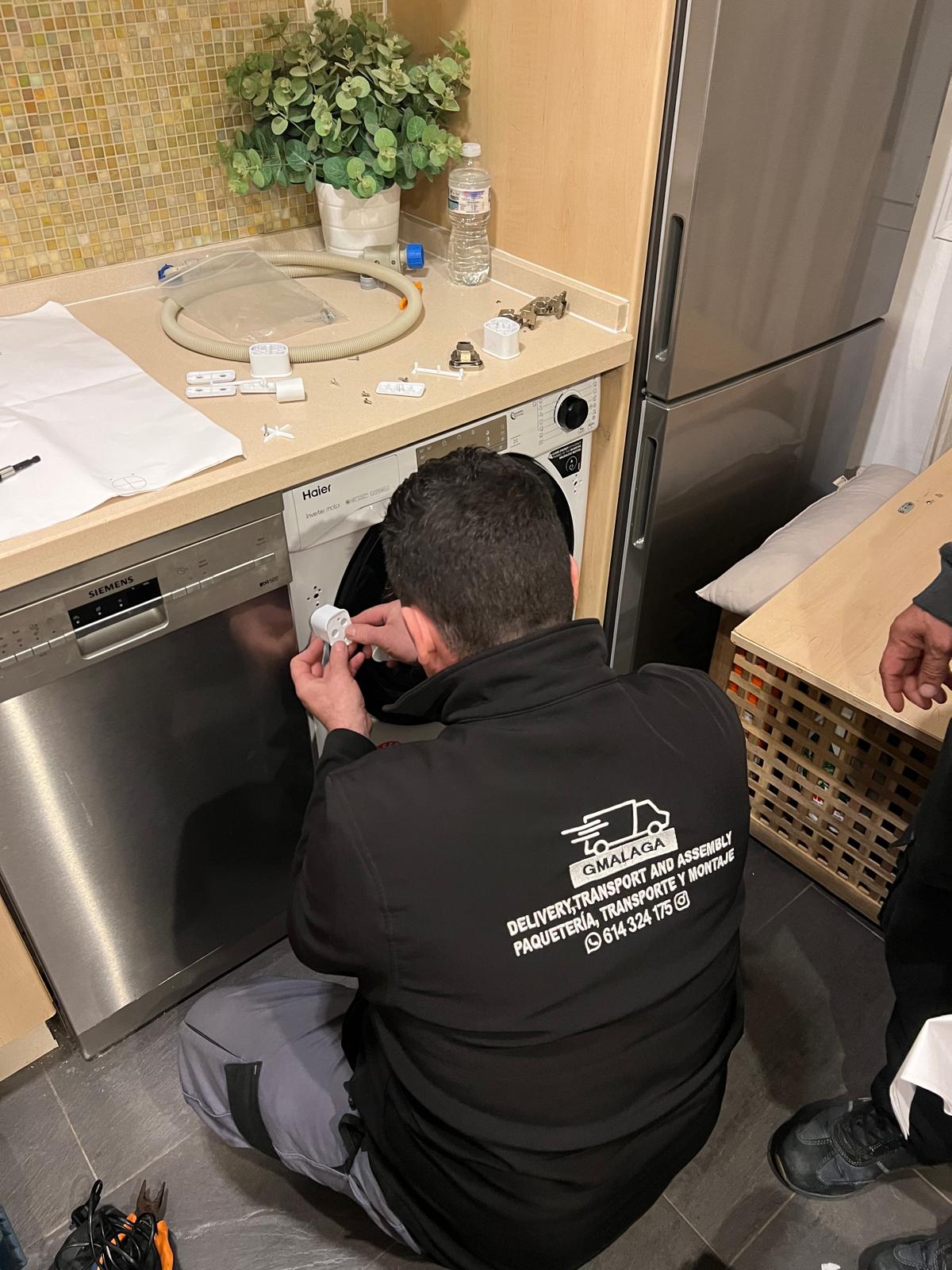 Técnico instalando un electrodoméstico en una cocina, con herramientas y material de montaje sobre la encimera.